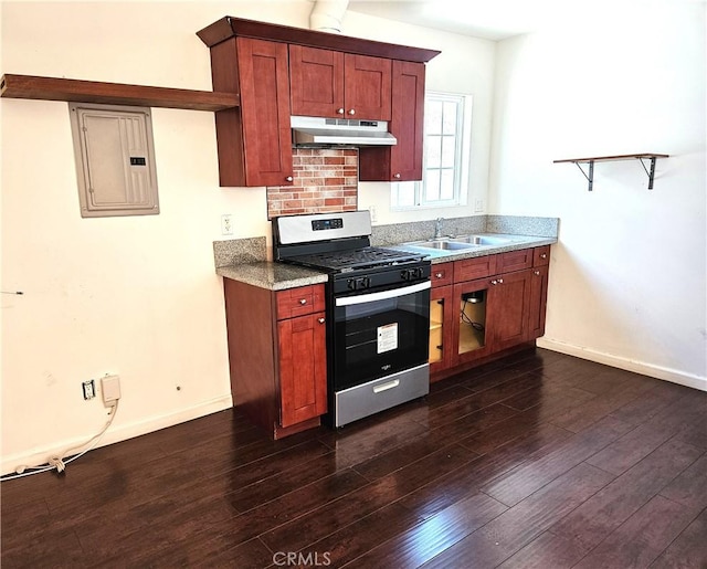 kitchen featuring dark wood-style floors, electric panel, a sink, under cabinet range hood, and stainless steel gas range oven