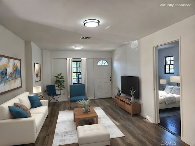 living room featuring dark wood finished floors, visible vents, and baseboards