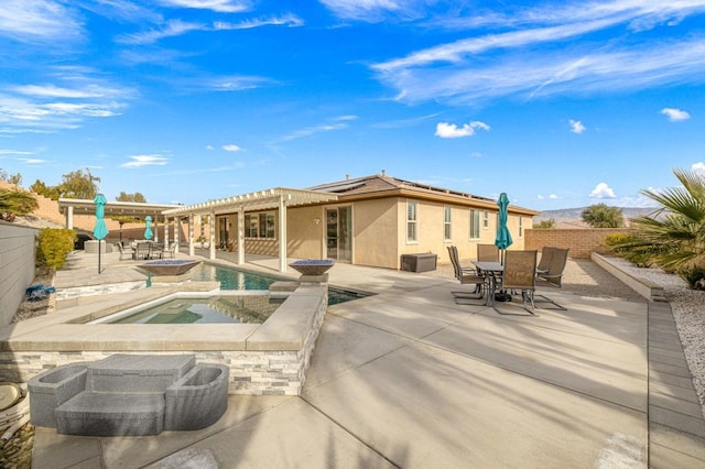 back of house featuring a swimming pool with hot tub, a pergola, and a patio area