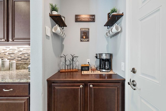 bar featuring dark brown cabinetry and backsplash