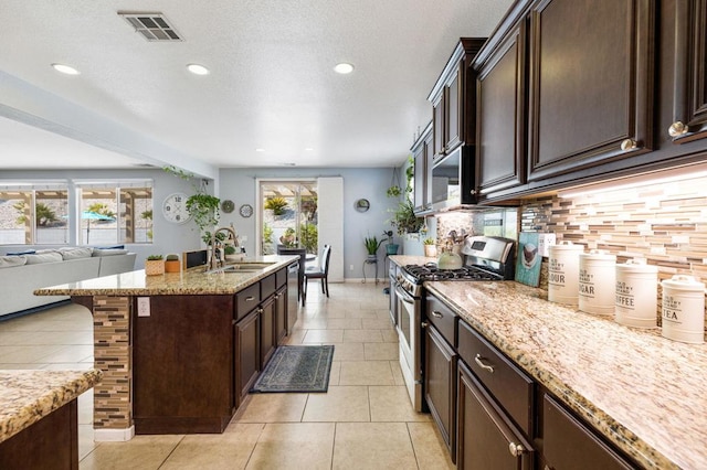 kitchen with sink, a breakfast bar area, light tile patterned floors, stainless steel appliances, and backsplash