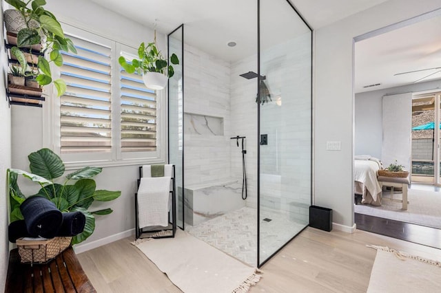 bathroom with an enclosed shower, hardwood / wood-style flooring, and ceiling fan