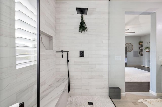 bathroom with ceiling fan and a tile shower