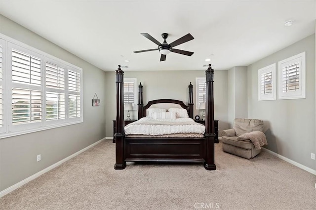 carpeted bedroom with ceiling fan and multiple windows