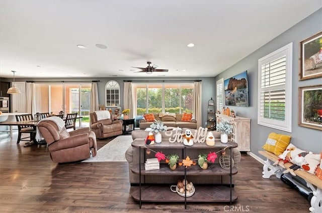 living room with dark wood-type flooring and ceiling fan