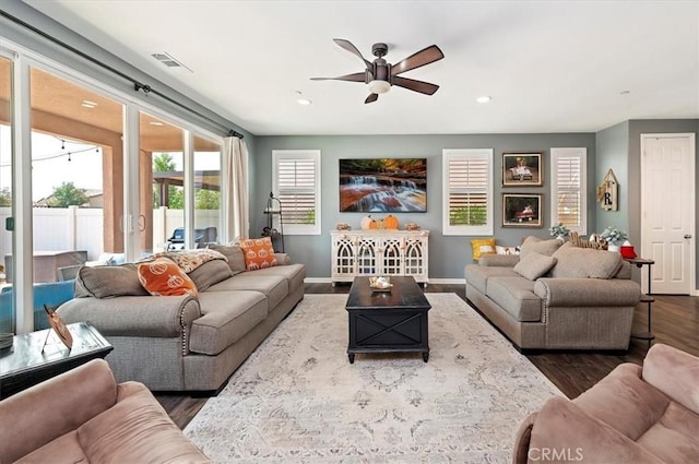 living room with ceiling fan and dark wood-type flooring