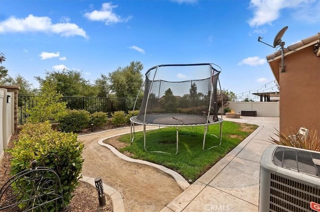 view of yard featuring a patio area, cooling unit, and a trampoline