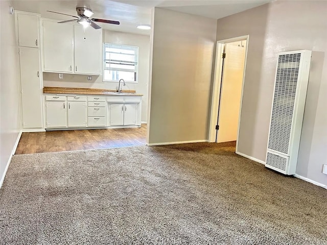 kitchen featuring light wood-type flooring, sink, ceiling fan, and white cabinets