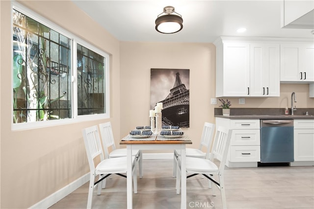 dining area with sink and light hardwood / wood-style flooring