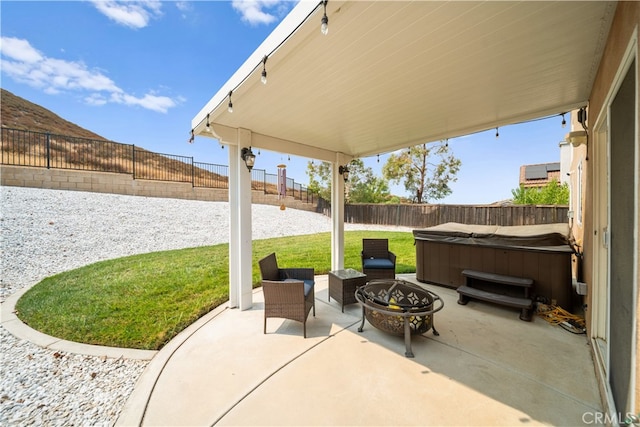 view of patio featuring a hot tub and a fire pit