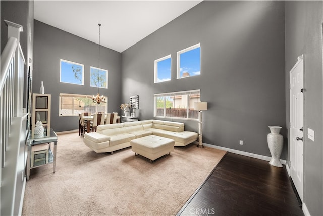 living room featuring a high ceiling, hardwood / wood-style floors, and a notable chandelier