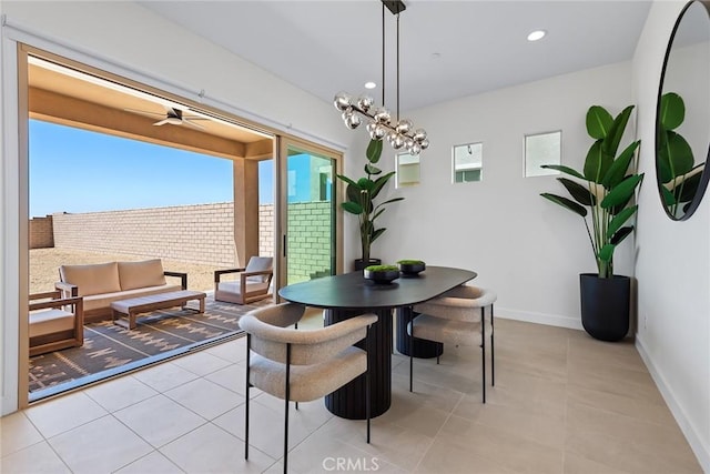 dining space with ceiling fan with notable chandelier and light tile patterned floors