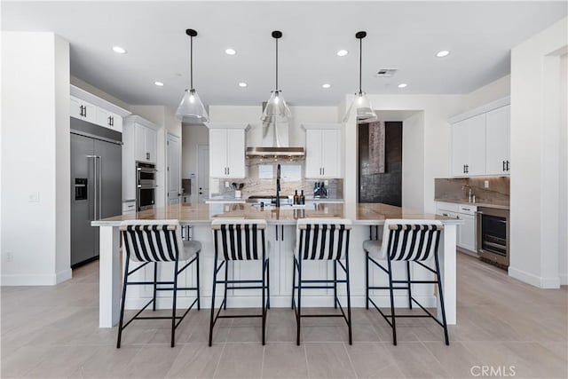 kitchen featuring a kitchen bar, a spacious island, hanging light fixtures, and stainless steel appliances