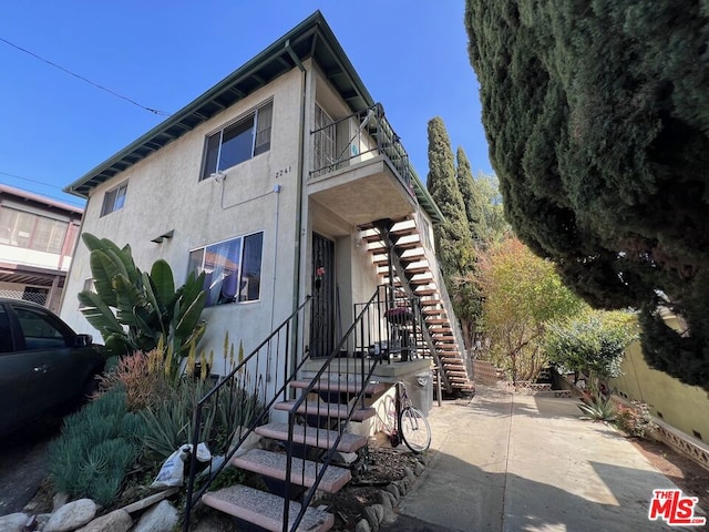 view of front of property featuring a balcony and a patio area