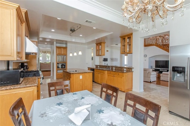 dining room with a raised ceiling, ornamental molding, and a chandelier