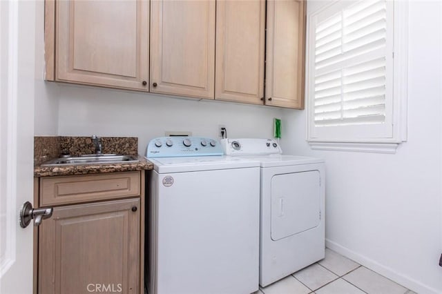 laundry room with cabinets, light tile patterned floors, washing machine and dryer, and sink