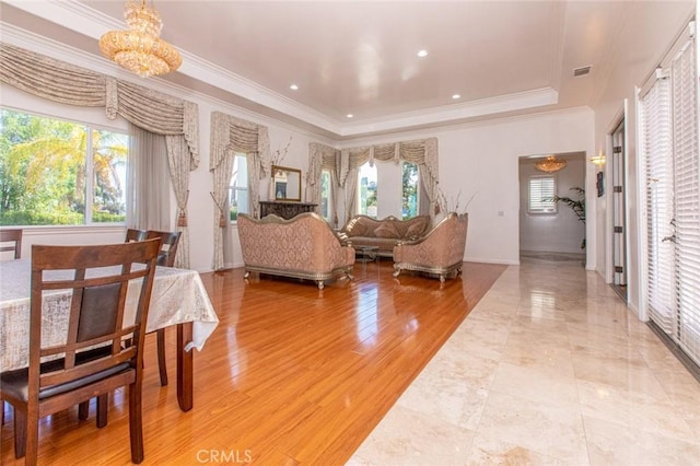 living room with hardwood / wood-style flooring, plenty of natural light, crown molding, and a tray ceiling