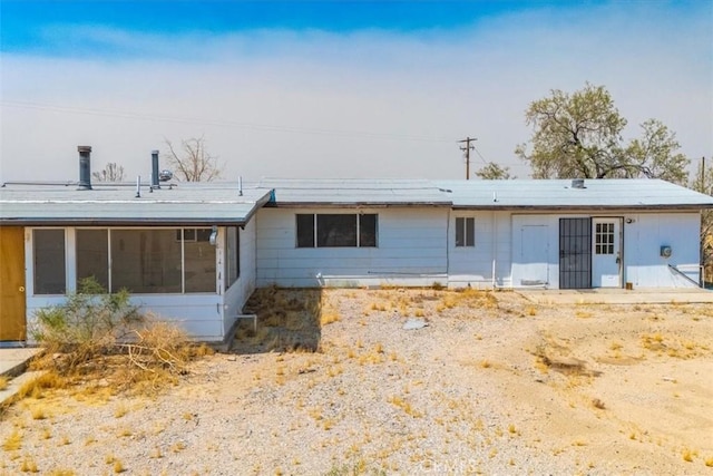 rear view of property featuring a sunroom