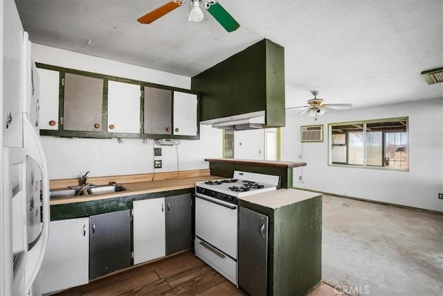 kitchen with sink, dark wood-type flooring, kitchen peninsula, a wall mounted AC, and white range with gas cooktop