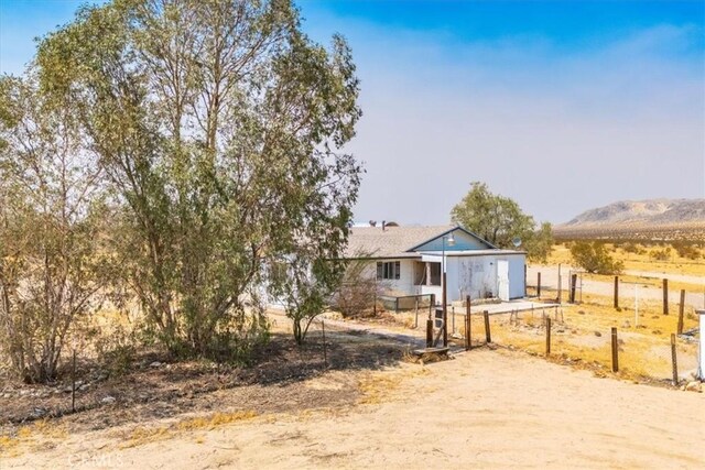 view of front of property with a mountain view and a rural view