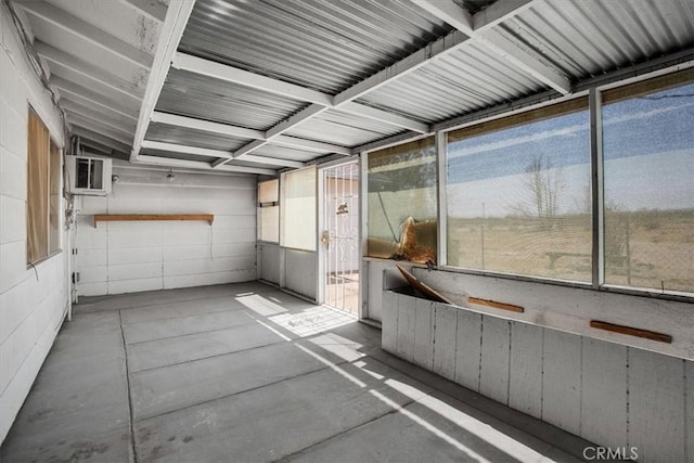 unfurnished sunroom with a wall mounted air conditioner and vaulted ceiling