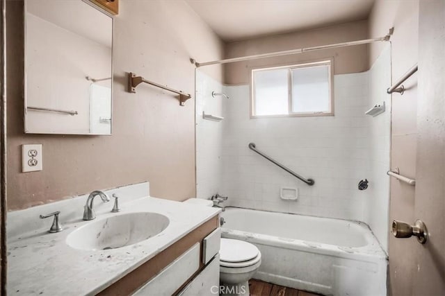 full bathroom featuring hardwood / wood-style flooring, vanity, tiled shower / bath combo, and toilet