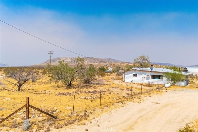 view of yard with a mountain view and a rural view