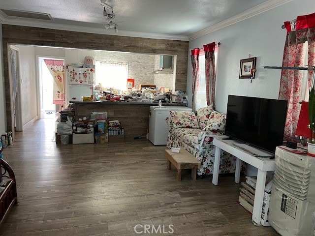 living room featuring hardwood / wood-style flooring, crown molding, a textured ceiling, and a healthy amount of sunlight