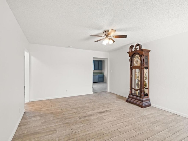 unfurnished living room with ceiling fan, a textured ceiling, and light hardwood / wood-style flooring