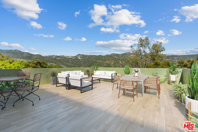 view of patio featuring outdoor lounge area and a deck with mountain view