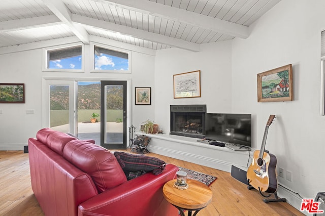 living room featuring wood-type flooring and vaulted ceiling with beams