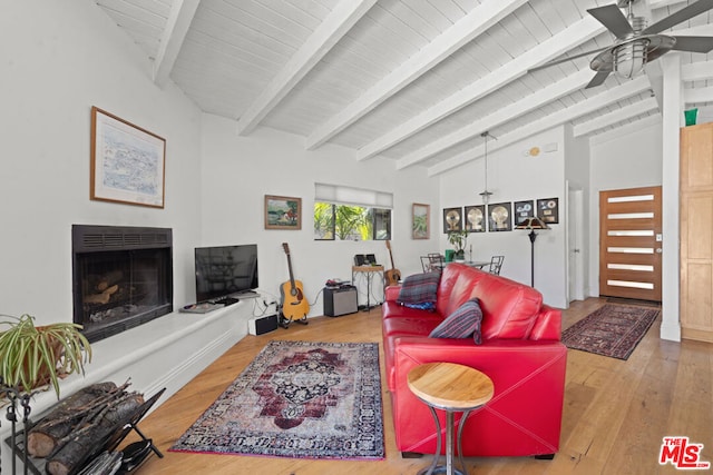 living room featuring ceiling fan, vaulted ceiling with beams, and hardwood / wood-style floors