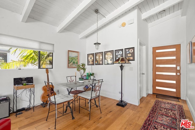 dining space featuring high vaulted ceiling, beam ceiling, light hardwood / wood-style floors, and wooden ceiling