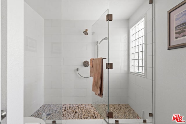 bathroom featuring toilet and a shower with shower door