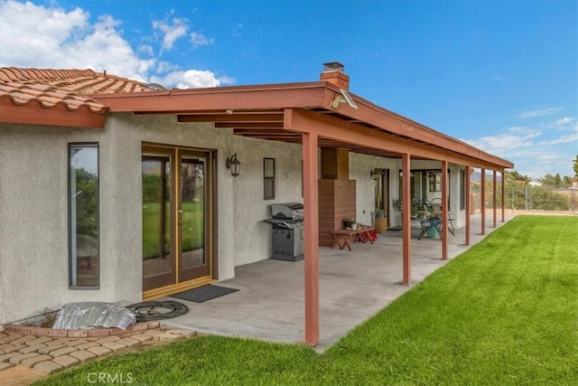 back of house with a patio and a lawn