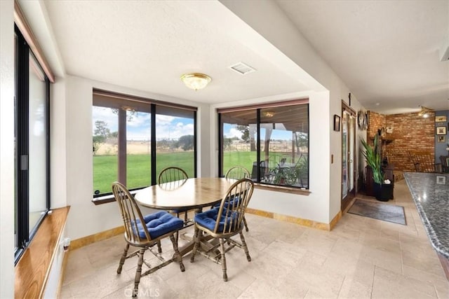 dining area featuring brick wall