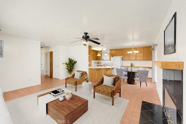 living room featuring ceiling fan with notable chandelier, light tile patterned floors, and a fireplace