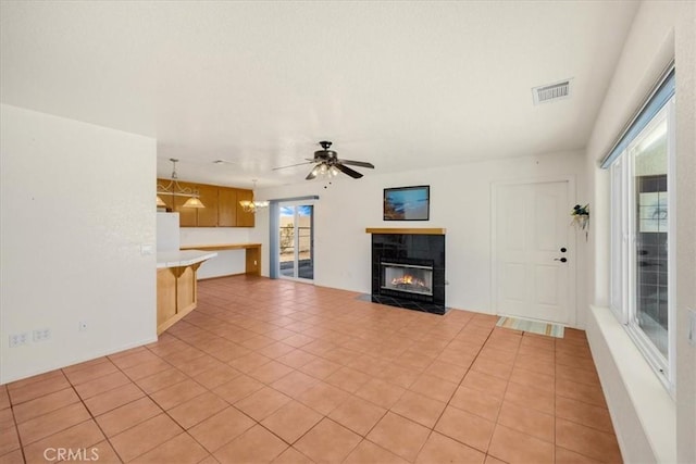 unfurnished living room with light tile patterned floors, a fireplace, and ceiling fan