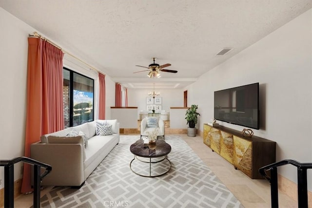 living room featuring ceiling fan, light carpet, and a textured ceiling