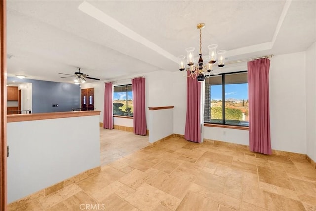 unfurnished room with a tray ceiling and ceiling fan with notable chandelier