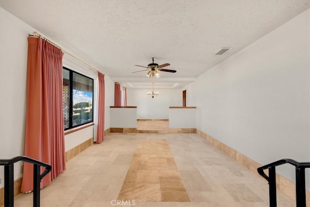 hallway featuring a chandelier and a textured ceiling