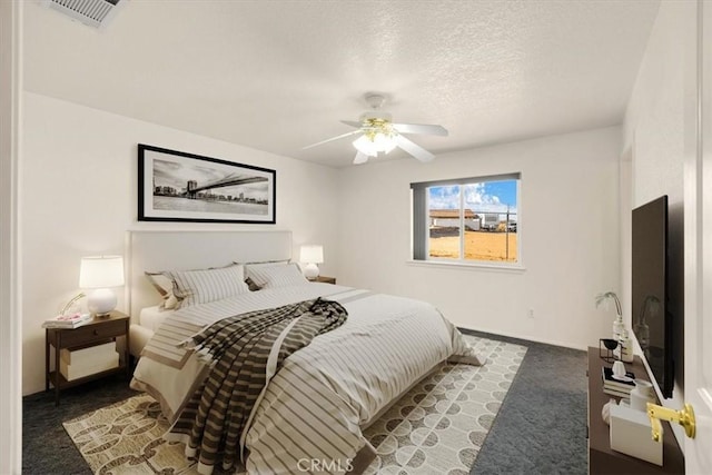 carpeted bedroom with a textured ceiling and ceiling fan