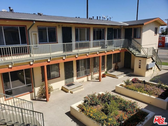 rear view of property with a patio and a balcony