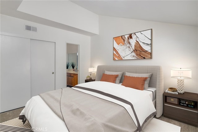 bedroom featuring ensuite bathroom, a closet, and light carpet