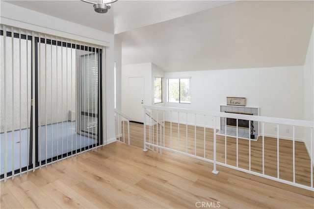 unfurnished room with wood-type flooring and vaulted ceiling