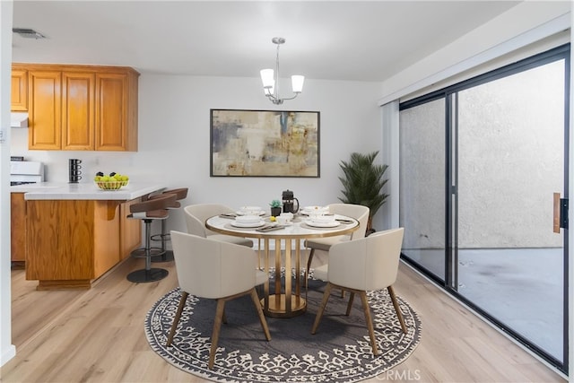 dining area featuring light hardwood / wood-style floors and a notable chandelier