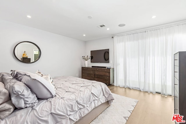 bedroom featuring light wood-type flooring and multiple windows