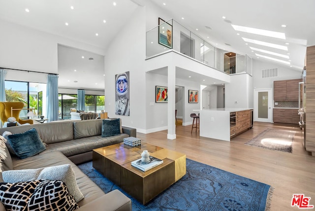 living room featuring light hardwood / wood-style flooring and high vaulted ceiling