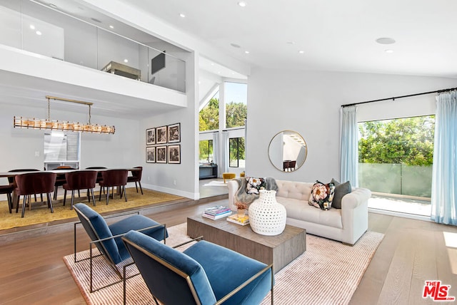 living room featuring high vaulted ceiling and light wood-type flooring