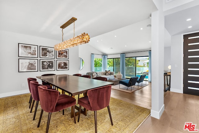 dining room with light hardwood / wood-style flooring and lofted ceiling